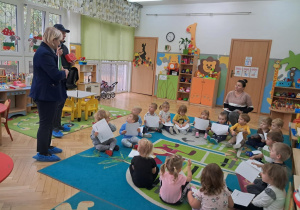 Pan listonosz pokazuje dzieciom paczki
