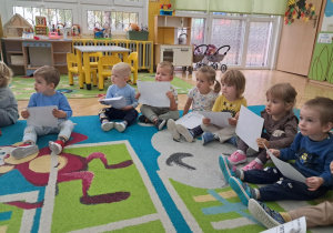 Pan listonosz rozdaje dzieciom znaczki i pocztówki