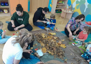 Nauczycielka rozdaje materiały do pracy