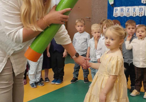 Nauczycielka pasuje dziewczynkę kredką