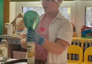 Nauczycielka pokazuje jak można nadmuchać balona nie używając ust