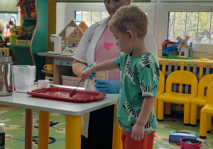 Dziecko miesza składniki do eksperymentu