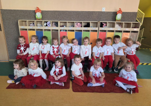 Dzieci ubrane na biało czerwono z okazji obchodów święta niepodległości pozują do zdjęcia.