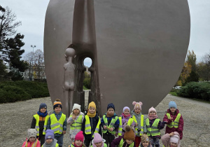 Dzieci pozują do zdjęcia przed pomnikiem pękniętego serca.