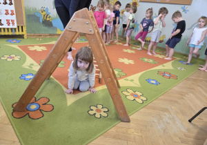Dziewczynka przechodzi pod drabinką