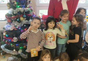 Grupa dzieci pozuje do zdjęcia z Mikołajem