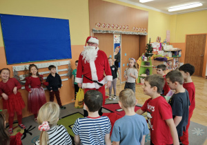 Dzieci stojące obok Mikołaja