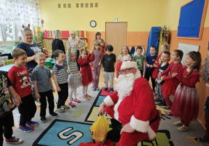 Mikołaj i stojące dzieci wokół niego