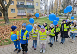 Dzieci na spacerze z niebieskimi balonami w ręku