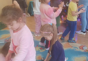 Dzieci ubierają choinkę.