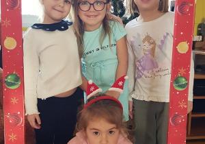 Dzieci pozują w świątecznej fotobudce.