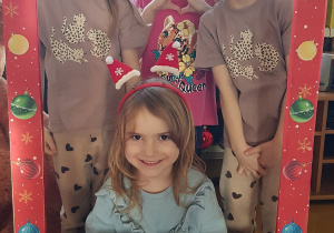Dzieci pozują w świątecznej fotobudce.
