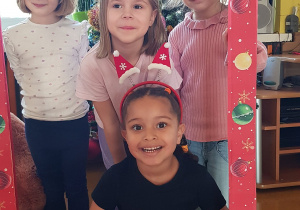 Dzieci pozują w świątecznej fotobudce.