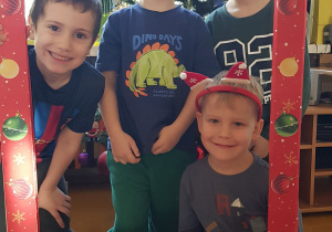 Dzieci pozują w świątecznej fotobudce.