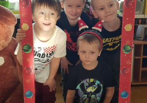 Dzieci pozują w świątecznej fotobudce.