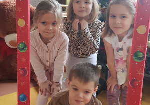 Dzieci pozują w świątecznej fotobudce.