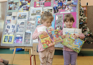 Dwie dziewczynki stoją z dyplomami w ręku