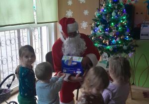Dzieci dostają słodkości od Mikołaja