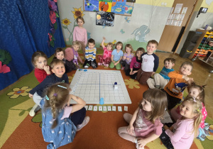 Dzieci kodują na dywanie z planszą