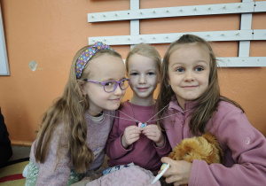 Trzy dziewczynki trzymają wspólnie naszyjnik serduszko