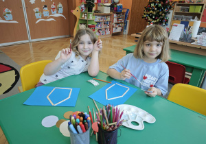 Dwie dziewczynki trzymają małe pędzelki