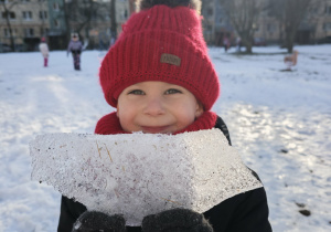 Chłopiec trzyma kawałek zmrożonego śniegu