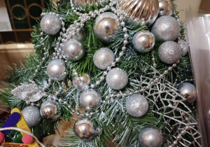 Stroik świąteczny z zielonych gałązek ze srebnymi bombkami
