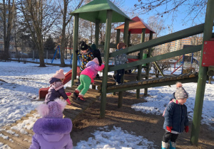 Dzieci bawią się w ogrodzie przedszkolnym na śniegu