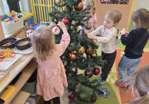 Dzieci ubierają choinkę