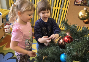 Dziewczynki ubierają choinkę