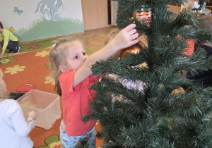 Dziewczynka ubiera choinkę