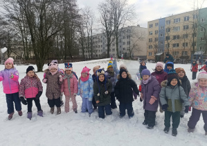 Grupa dzieci pozuje do zdjęcia na śniegu