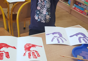 Dziecko podczas malowania - stemplowania dłoni w farbie.