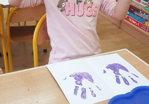 Dziecko podczas malowania - stemplowania dłoni w farbie.