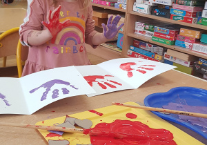 Dziecko podczas malowania - stemplowania dłoni w farbie.