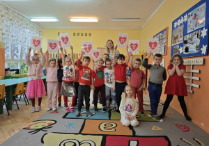 Dzieci ubrane na czerwono unoszą literki