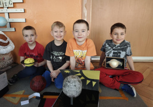Czterech chłopców pokazuje modele planet
