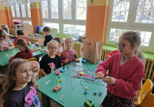 Cztery dziewczynki wykonują prace kreatywną przy zielonym stole