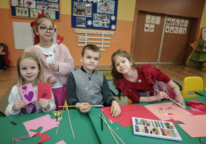 Dzieci trzymają długie patyczki z których zrobią dekorację walentynkową