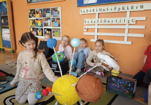 Dziewczynka na forum grupy pokazuje Układ Słoneczny