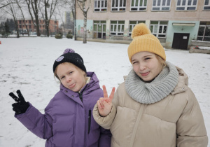 Dwie dziewczynki w ogrodzie przedszkolnym na śniegu