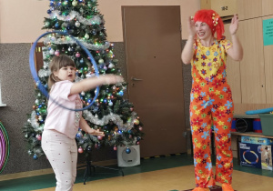 Dziewczynka kręci dużą obręczą na swojej rączce