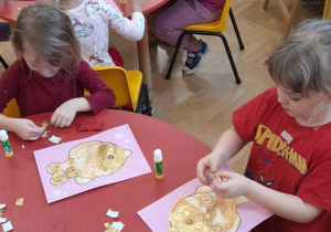 Dzieci naklejają łuski na rybę