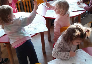 Dzieci rysują po śladach.