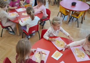 Dzieci malują złotą farbą rybkę