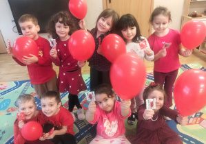 Dzieci ubrane na czerwono pozują do zdjęcia