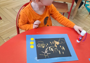 Chłopiec wykonuje prace plastyczne