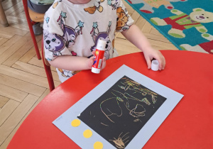 Dziewczynka wykonuje prace plastyczną