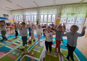 Dzieci wykonują ćwiczenia które pokazuje nauczycielka