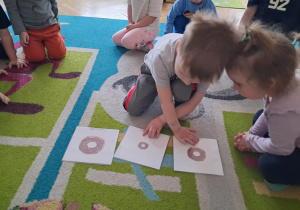 Chłopiec układa obrazki według instrukcji nauczyciela